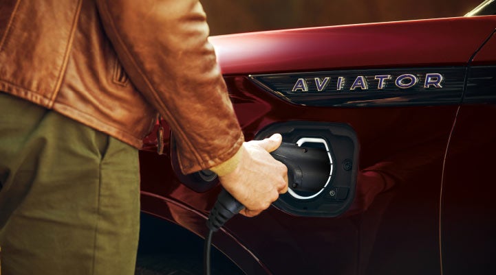 A hand is shown plugging in the charger into the charging port of a 2021 Lincoln Aviator | Griffin Lincoln in Tifton GA